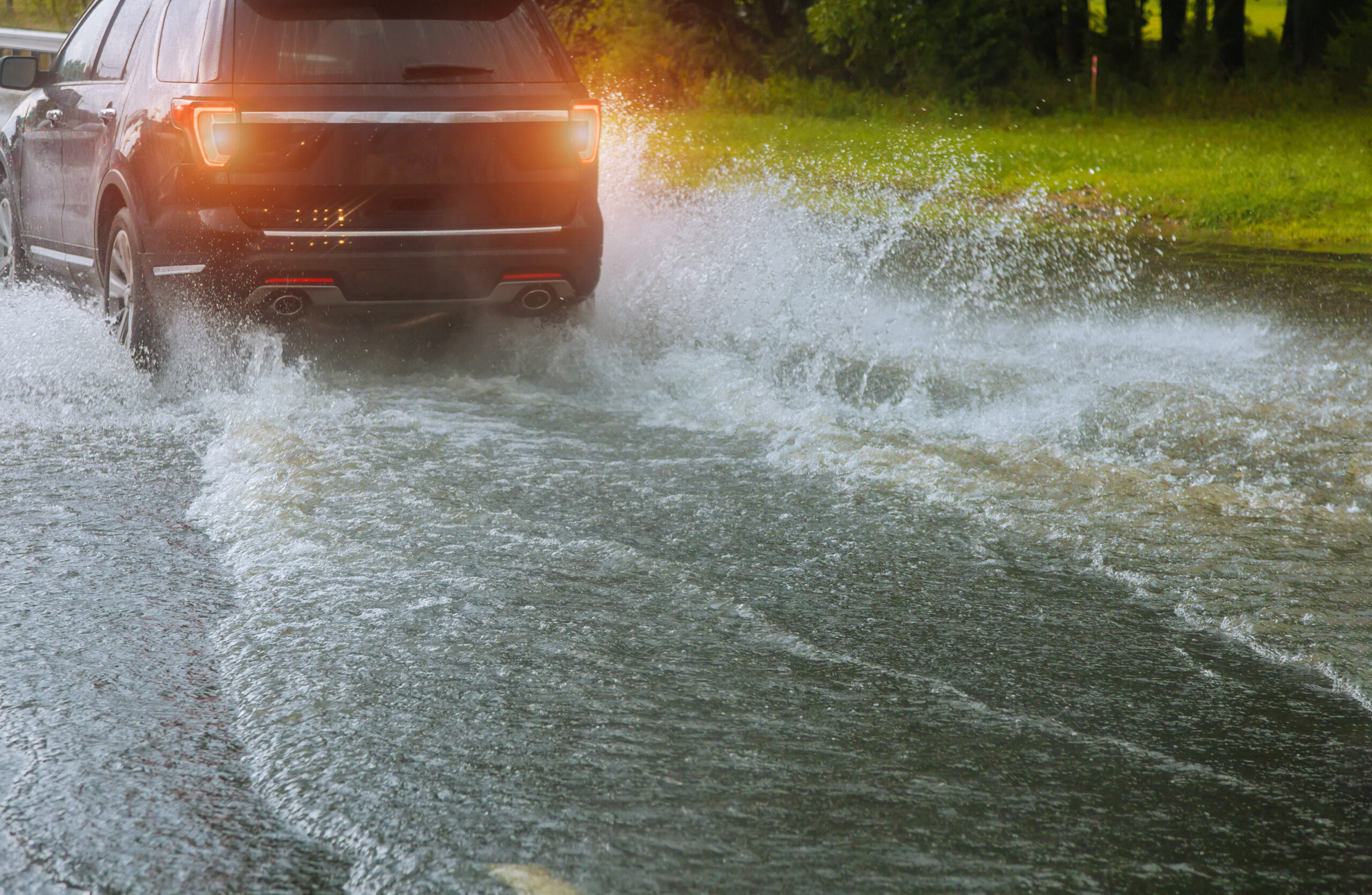 Spraying Water Of A Car Moving Driving Car On Flooded Road During Flood Caused By Torrential Rains Cars Float On Water Flooding Streets